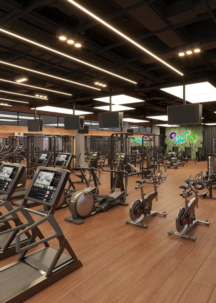 Academia ampla com equipamentos e iluminação linear